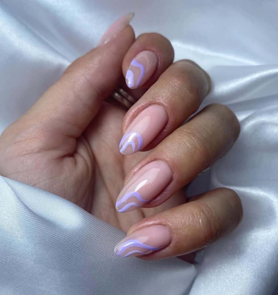 Hand with short almond shaped nude nails featuring soft lavender wavy French tip accents, creating a subtle and modern manicure with a clean, minimalist look.